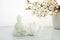 Vesak, Wesak, Buddha birthday. Buddha statue with blossoming cherry on white background. Spa ritual. Mental health and