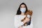 Vet with dog in medical masks. Attractive veterinarian holds yorkshire terrier. Pandemic. Coronavirus concept. Health
