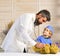 Vet and little assistant examine teddy bear. Father and kid