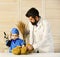 Vet and little assistant examine teddy bear. Father and kid with attentive faces playing doctor.