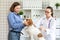 The vet makes a dog an injection syringe. The owner keeps the dog. Blurred background of veterinary clinic.