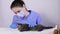 A veterinarian in a blue uniform gives pills to a kitten.