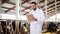 Veterinarian with cows in cowshed on dairy farm