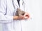 Veterinarian doctor holding and feeding water to baby gray rabbit over white background.