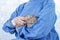 Veterinarian doctor or nurse wear blue uniform coat holding sick young rabbit in hand at hospital. Veterinary woman wear blue coat