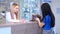 A veterinarian examines a cat held in the arms of the owner of the animal. The doctor on duty at the veterinary clinic