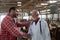 Veterinarian and farmer shaking hands in cow stable