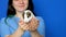 Veterinarian holds baby guinea pig in his hands and smiles on a blue background