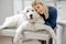 Veterinarian hugs the patient big white dog