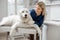 Veterinarian hugs the patient big white dog