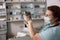 Veterinarian with medical mask holds cute little tabby kitten at appointment in clinic