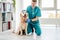 Veterinarian stroking golden retriever dog