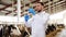 Veterinarian with syringe vaccinating cows on farm