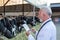 Veterinarian with tablet in front of cows in barn