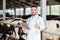 Veterinarian with tablet pc and cows on dairy farm