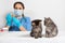 The veterinarian and two small kittens in the doctor's office. Veterinary clinic, vaccination.