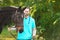 Veterinarian in uniform with beautiful brown horse outdoors