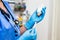 The veterinarian women with blue gloves and  stethoscope extract a white drug with a syringe