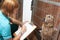 Veterinary Nurse Checking On Dog In Cage