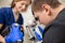 A veterinary ophthalmologist makes a medical procedure, examines the eyes of a dog with an injured eye and an assisent helps her