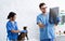 Veterinary surgeon examining animal xray and his assistant with tabby cat at animal clinic