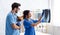 Veterinary surgeons reading radiograph while holding little dog at clinic