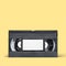 VHS video tape cassette on yellow background