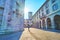 Via Pretorio street with sun above Broletto tower, Como, Italy