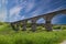 Viaduct. Beautiful old arched stone railway bridge against the backdrop of a scenic landscape