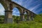 Viaduct. Beautiful old arched stone railway bridge against the backdrop of a scenic landscape