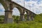 Viaduct. Beautiful old arched stone railway bridge against the backdrop of a scenic landscape