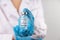 Vial with COVID-19 vaccine against coronavirus infection in the hand of a doctor in a nitrile glove on a white background. Close-