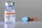 Vial with COVID-19 vaccine and syringe with vaccine droplet needle close-up