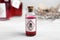 Vial of poison with warning sign on white wooden table, closeup