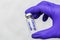 Vial with the vaccine in the hands of a doctor in blue protective surgical gloves inscription on the vial COVID19 vaccine