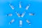Vials, ampoules with a dry probiotic, bifidobacteria inside on a blue background are laid out in the form of a clock. Copy space
