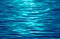 Vibrant aqua blue colored sea ripples with sunlight reflections