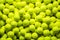 Vibrant assortment of tennis balls on a seamless green background pattern for sports themed designs