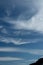 A Vibrant atmospheric cloudy sky cloudscape with white coloured wispy cirrus cloud formation in a mid blue sky