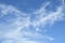 A Vibrant atmospheric cloudy sky cloudscape with white coloured wispy cirrus cloud formation in a mid blue sky