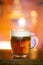 Vibrant Beer Glass with Frothy Foam on Orange Background