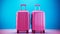 Vibrant blue backdrop with two bright pink suitcases, travel luggage set for vacation