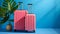 Vibrant blue background with two bright pink suitcases, travel luggage set for vacation