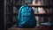 Vibrant blue backpack filled with essentials sits on a wooden table amidst blurred bookshelves.