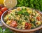 A vibrant bowl of fresh tabbouleh salad garnished with a sprig of mint, surrounded by ingredients like tomatoes and olive oil, set