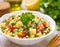 A vibrant bowl of fresh tabbouleh salad garnished with a sprig of mint, surrounded by ingredients like tomatoes and olive oil, set