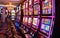 A vibrant casino interior featuring a row of colorful, illuminated slot machines ready for play.