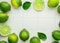 Vibrant Citrus Refreshment: Limes and Green Leaves Decoration on a White Tile Background for Fresh Summer Flavors in the Kitchen