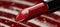 Vibrant close up detailed macro shot of glossy red lipstick on neutral background