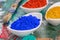 Vibrant color pigments in porcelain bowls on a wooden palette